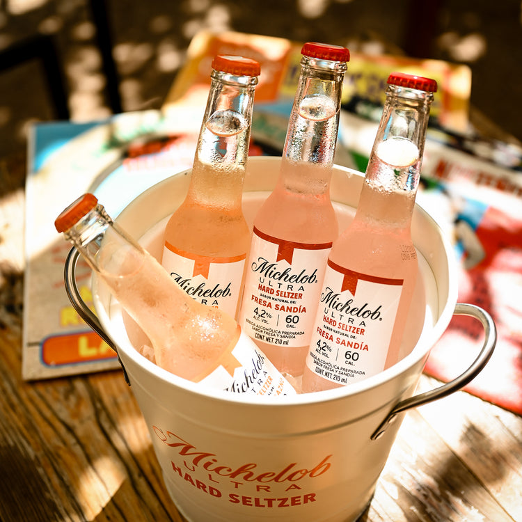 Botellas en una cubeta con hielo bajo luz natural